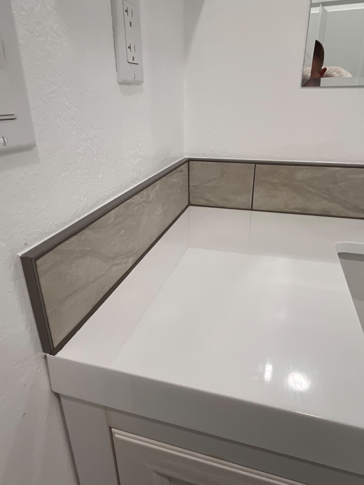 Tiled backsplash finished behind a bathroom vanity counter