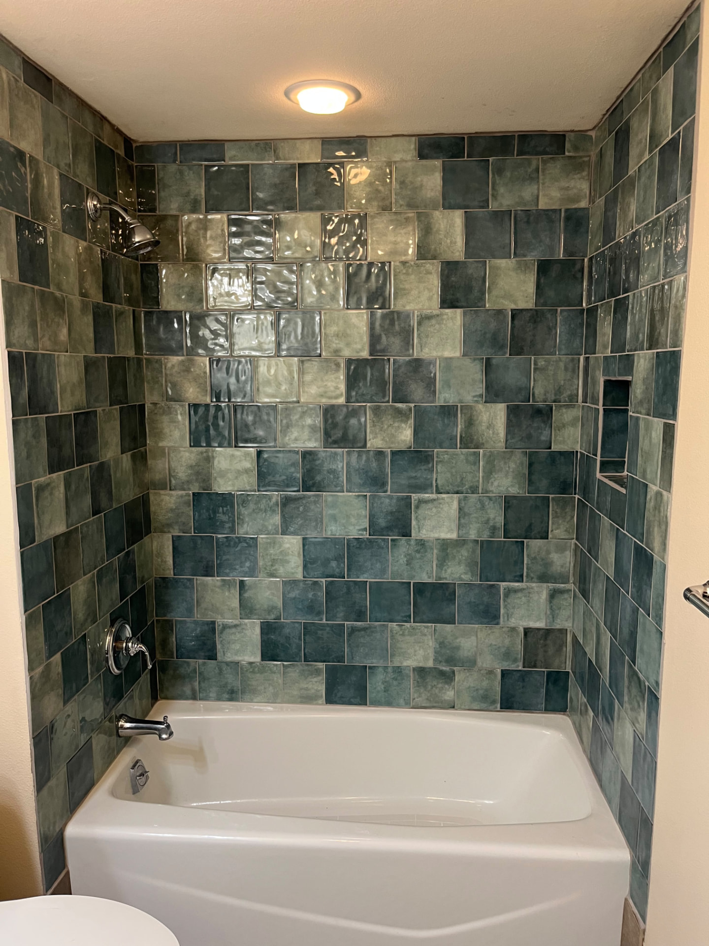 Finished green tile bathtub and shower surround