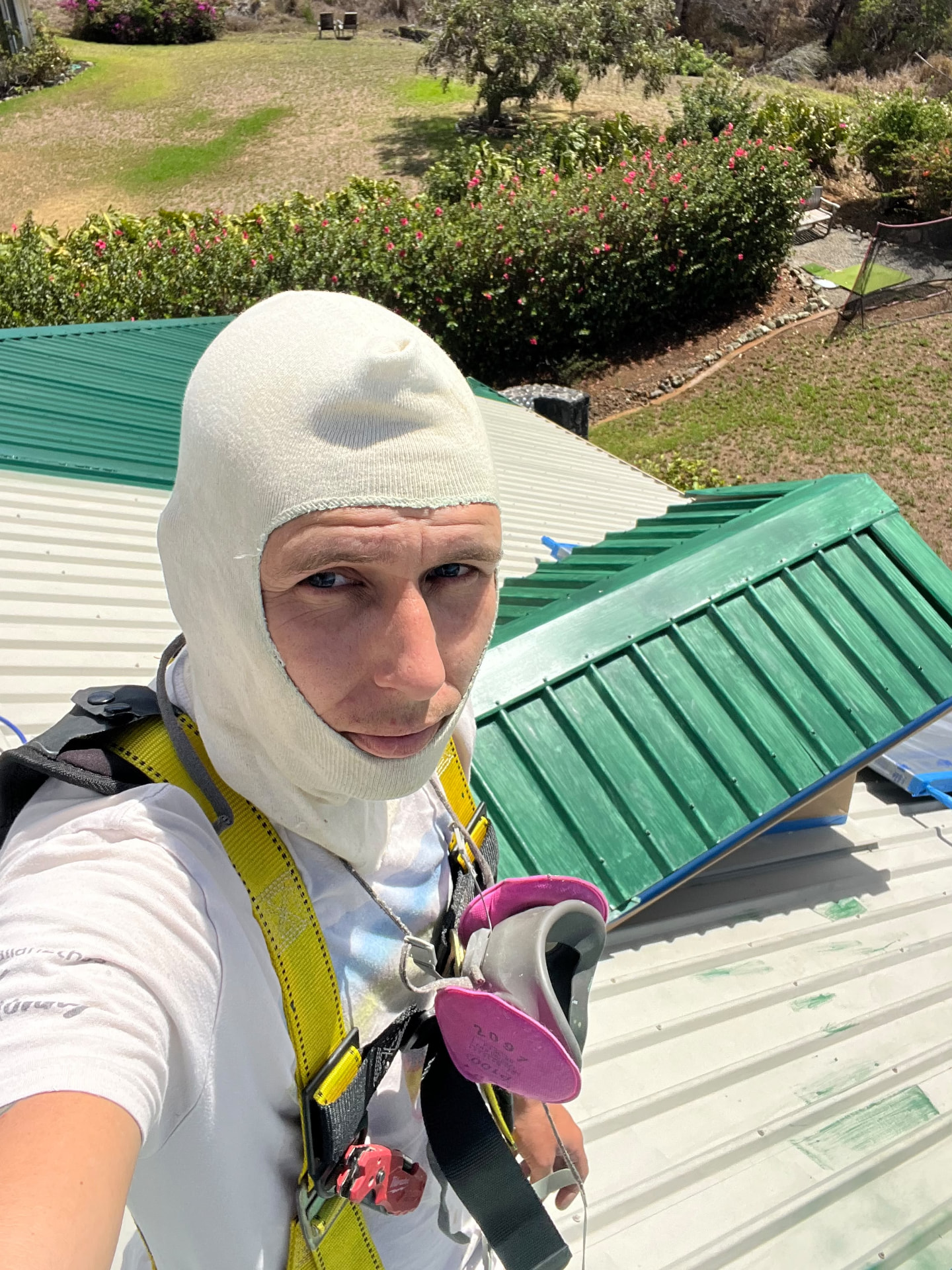 Jordan in harness and respirator on a metal roof job
