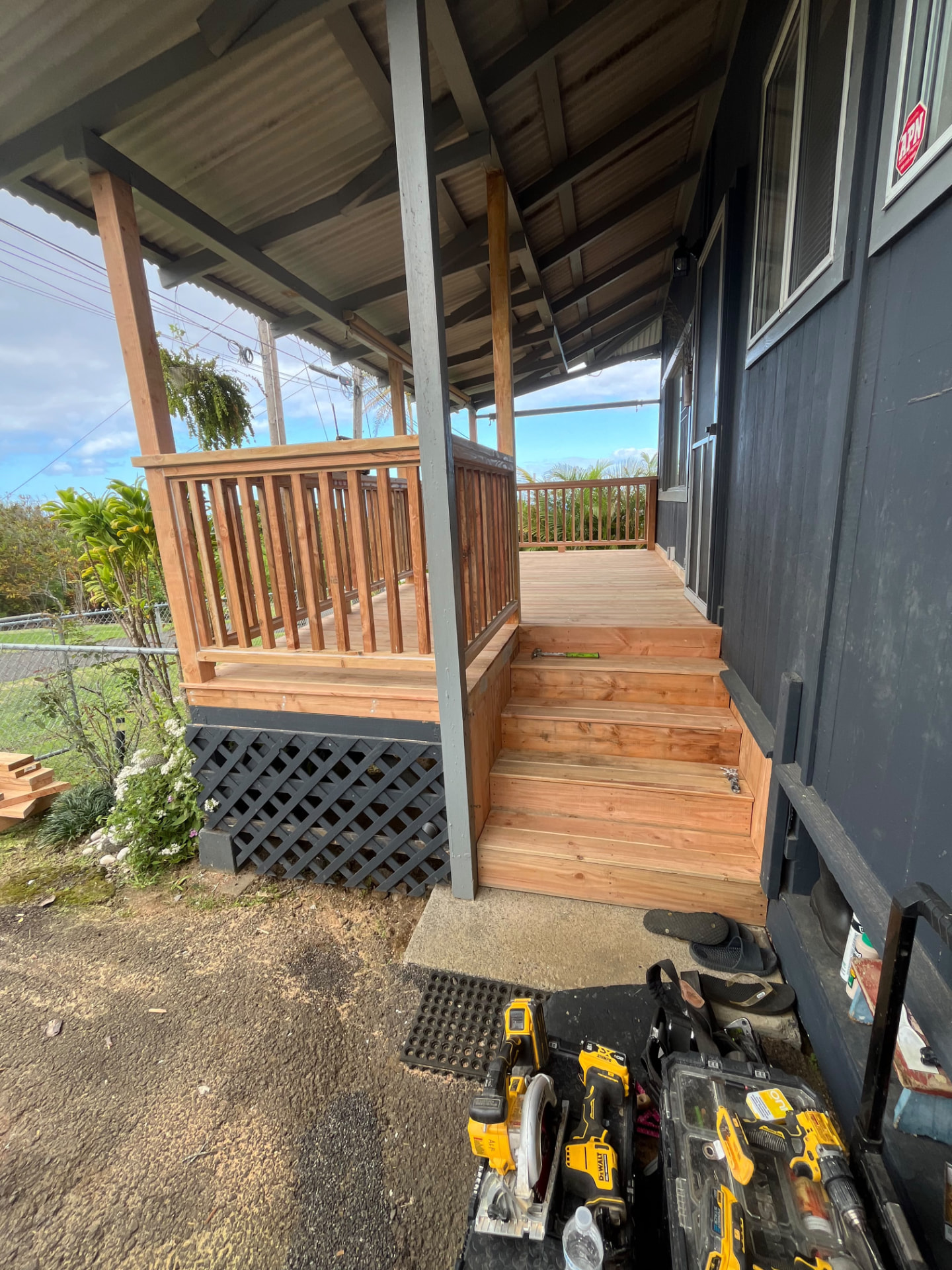 New wood lanai deck with railings and stairs under a covered porch