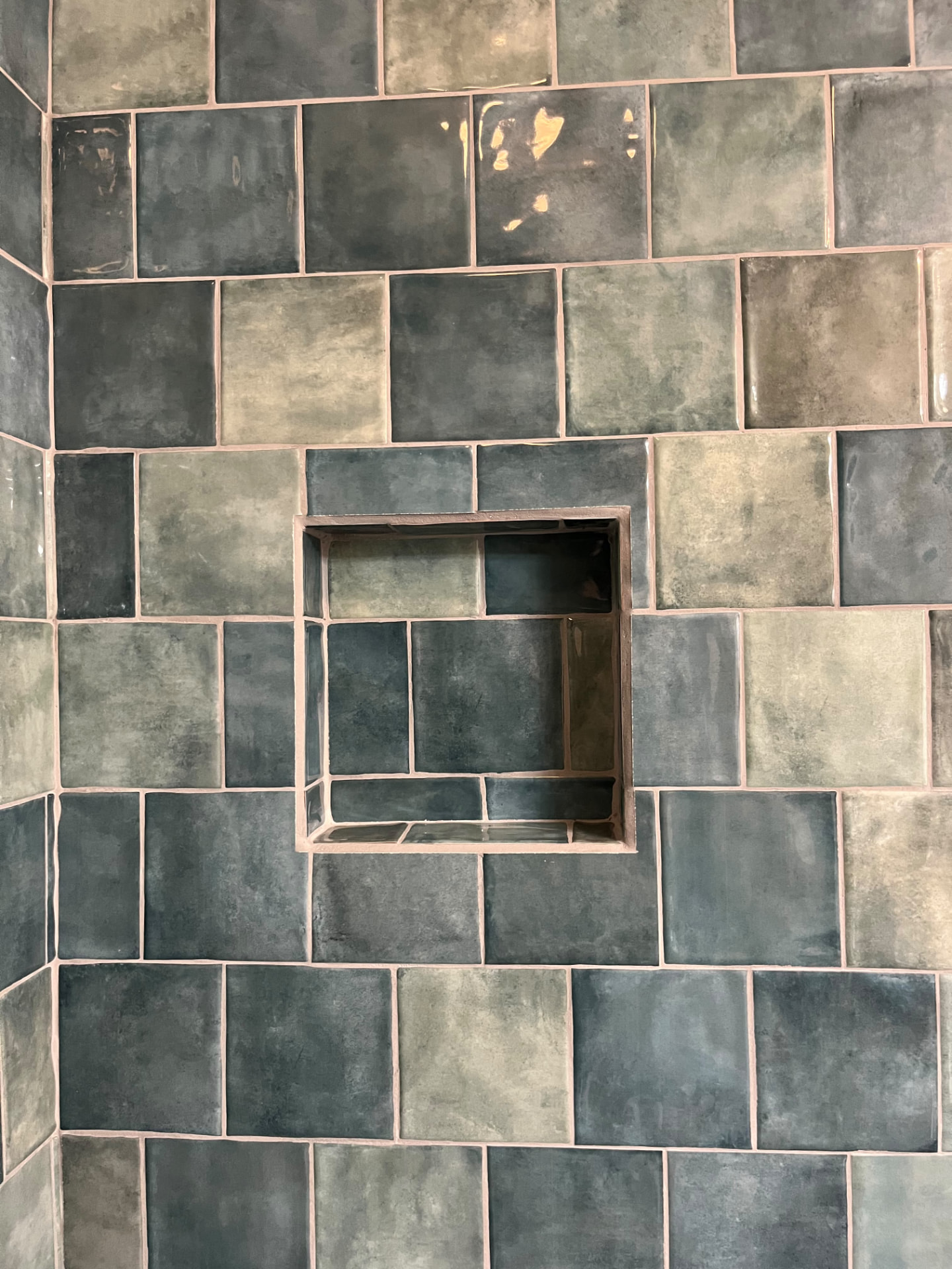 Finished dark tile shower with a recessed niche